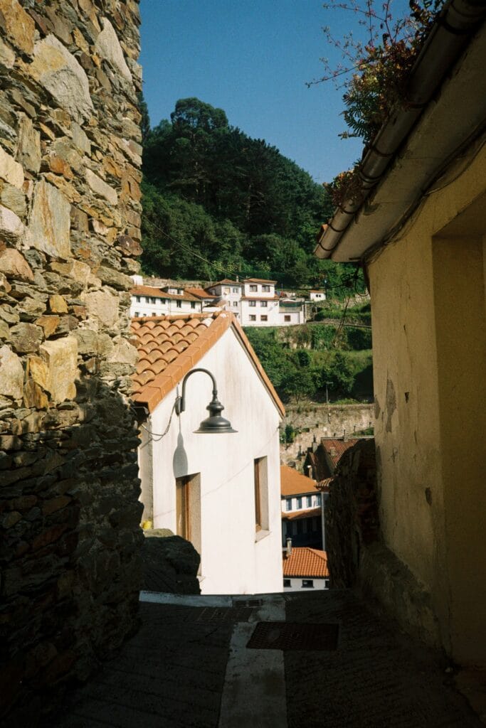 Calle estrecha con casas tradicionales y tejados de teja roja en un pueblo del norte de España